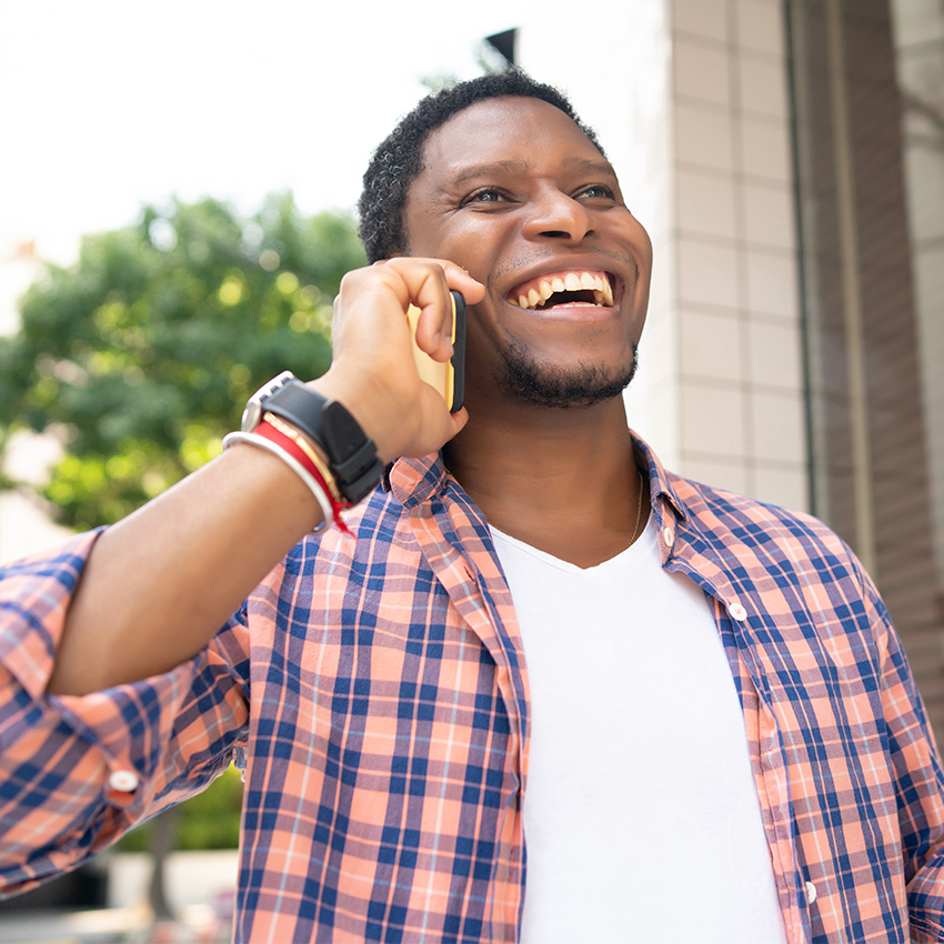 Man laughing while on the phone.